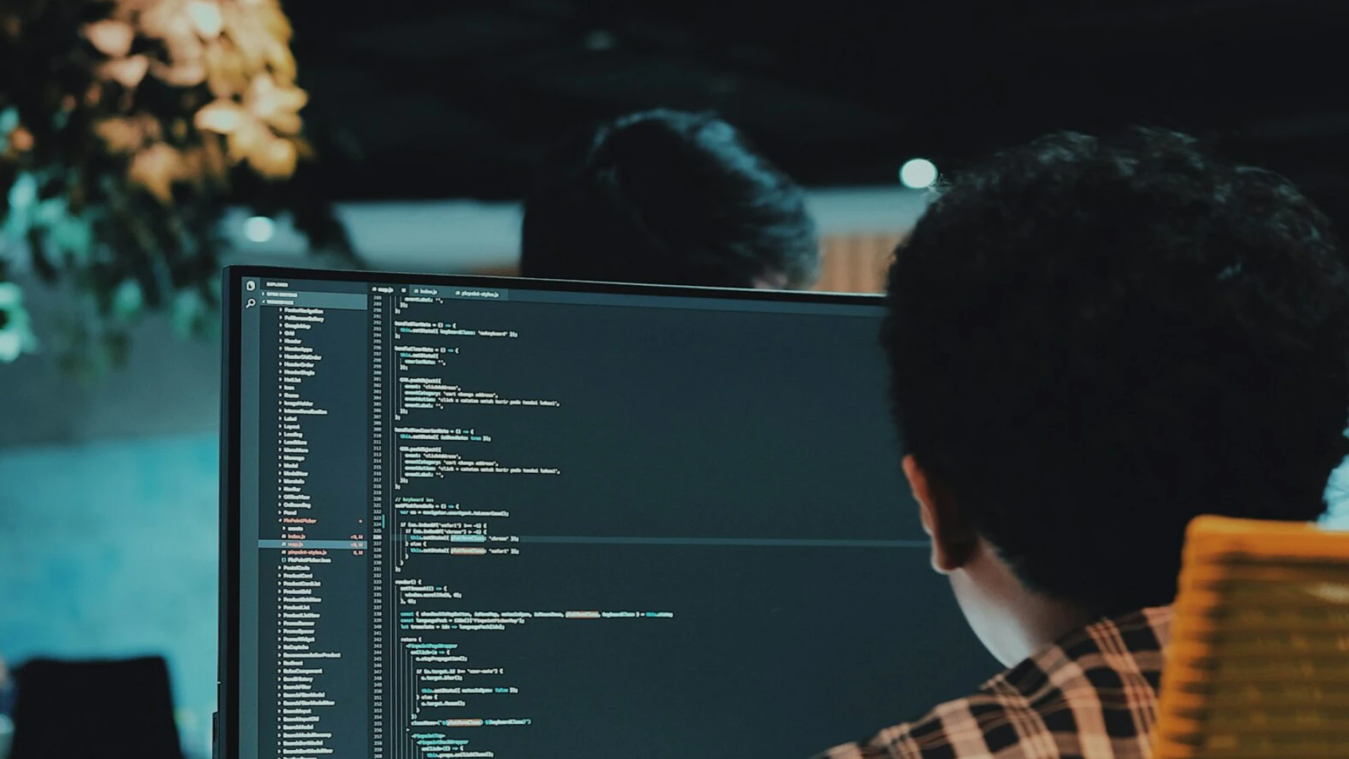 A guy behind a computer with the code running