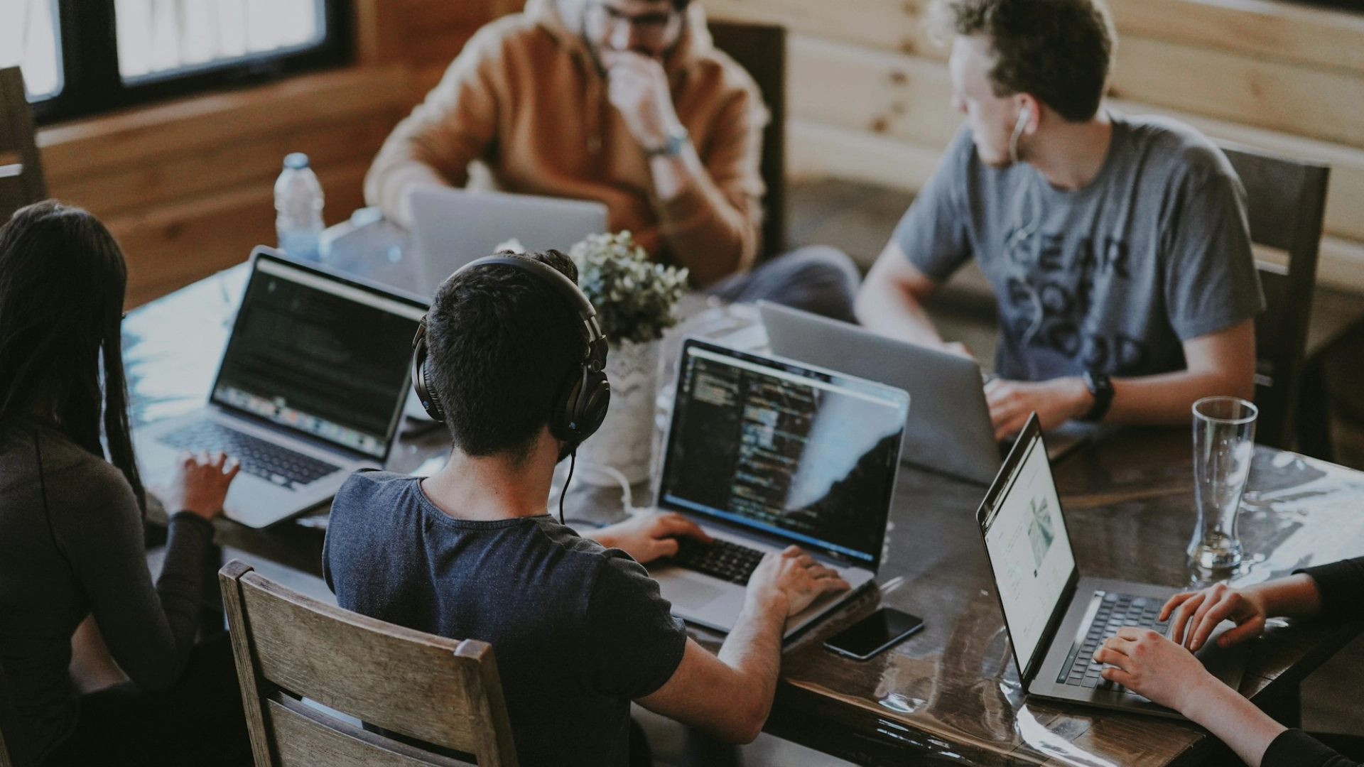 A team of colleagues brainstorming together in the office setting behind a table.